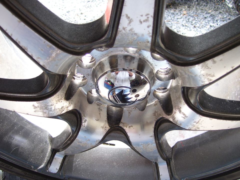Close-up of a chrome multi-spoke alloy wheel with center cap and lug nuts