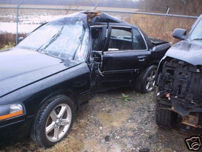 1993 Ford Crown Victoria - Two vehicles sustained significant damage, with the sedan's roof and windshield compromised.