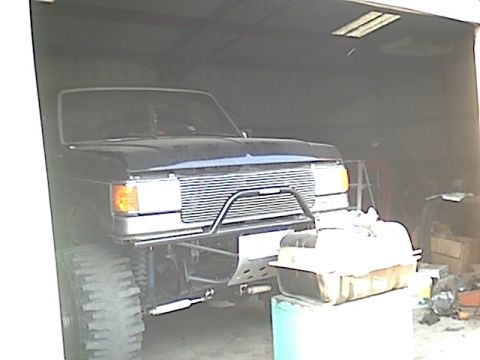 1987 Ford Bronco - Front view of a black 1987 Ford Bronco, modified with a custom grille guard and off-road tires.