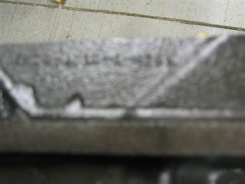 1972 Ford Ranchero - A close-up view of a metal component with some stamped markings and a diagonal line.