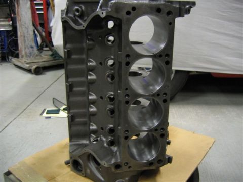 1972 Ford Ranchero - A gray engine block is shown in a garage setting, with a partial vehicle in the background.