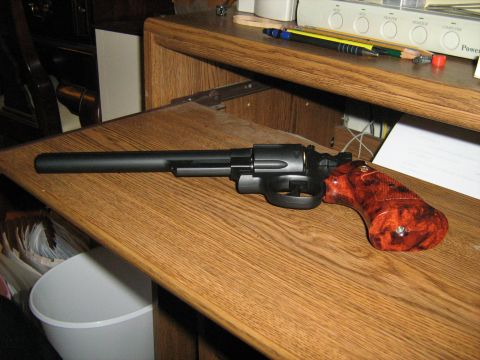 1988 Mercury Grand Marquis - A revolver with distinctive grips is placed on a desk next to office supplies.