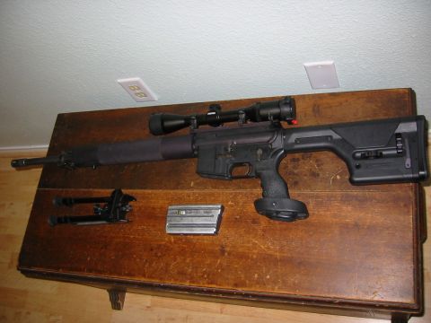 1996 Ford Bronco - A rifle equipped with a scope, bipod, and magazine is displayed on a wooden table.
