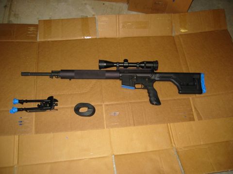 1996 Ford Bronco - Sniper rifle with scope and bipod laid out on cardboard.