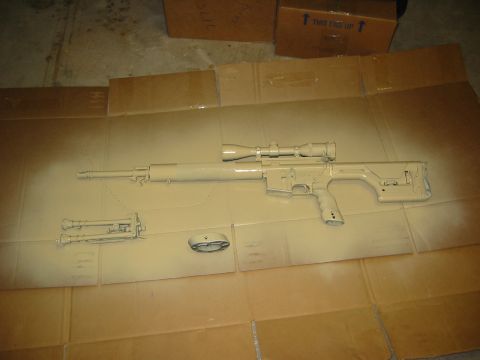 1996 Ford Bronco - A rifle, scope, and bipod are laid out on cardboard, covered in a fresh coat of tan spray paint.