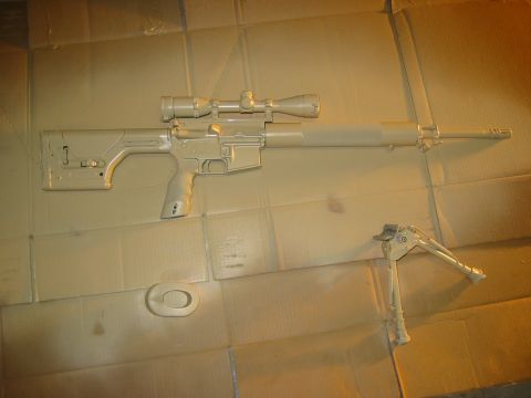 1996 Ford Bronco - A rifle with a scope and bipod is shown against a cardboard background.