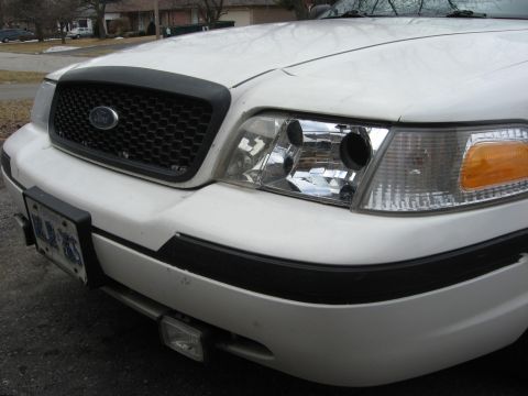 2003 Ford Crown Victoria - Front view of a white 2003 Ford Crown Victoria showing the grille and headlights.