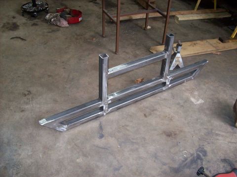 1992 Ford Bronco - Unfinished custom metal sliders are shown on a workshop floor, ready for installation.