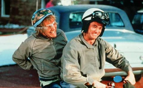1974 Ford Ranchero - Two men in helmets ride a motorcycle, with a car visible in the background.
