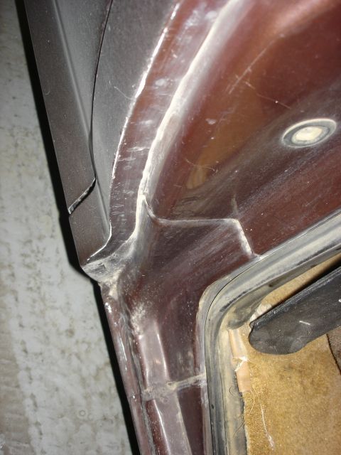 1979 Ford F-250 - This image shows a close-up view of the door jamb area of a vehicle, revealing the rubber seal and the painted metal frame.