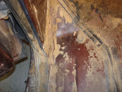 1979 Ford F-250 - Close-up view of a dirty interior body panel, showing rust and accumulated debris.