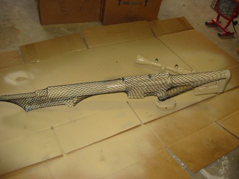 1996 Ford Bronco - A car part is being prepared for a camouflage paint job using netting.