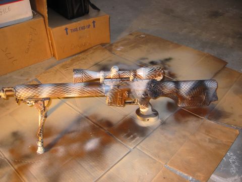 1996 Ford Bronco - A sniper rifle is shown with a camouflage paint job, resting on a cardboard surface.