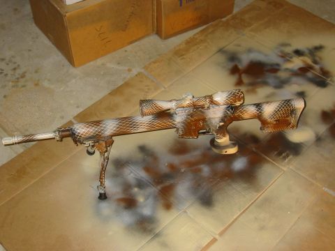 1996 Ford Bronco - Sniper rifle with camouflage paint job is shown on a cardboard surface.