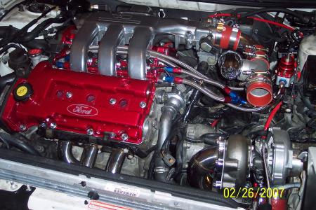 1994 Ford Probe - Customized engine bay a red Ford valve cover and a prominent turbocharger installation.