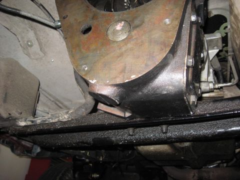 1991 Ford Bronco - A close-up view of a vehicle's undercarriage reveals the transmission housing and surrounding mechanical components.