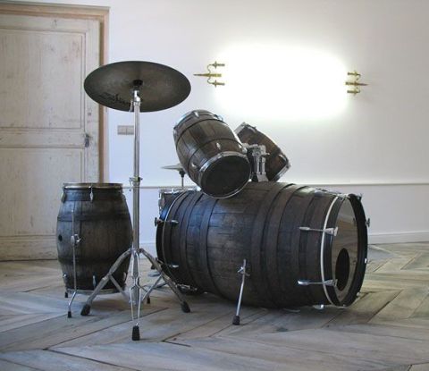 1990 Ford Bronco - A drum set made from wooden barrels is displayed in a room with a white wall and wooden floors. The drum set includes a large bass drum, a…