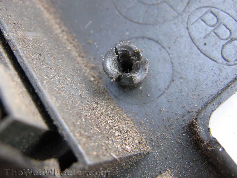 Damaged plastic fastener on dusty gray surface