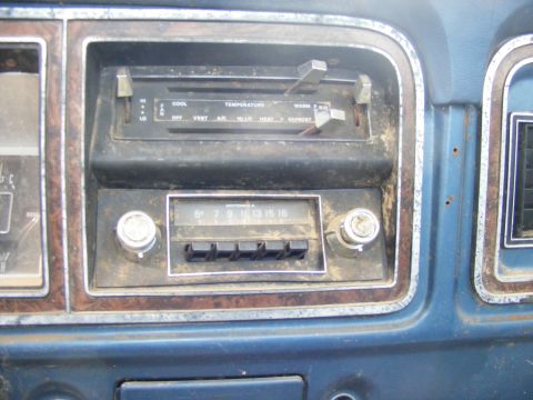 1985 Ford Bronco - The image shows a close-up view of the dashboard of a vintage vehicle, featuring an old Motorola radio and climate controls. The dashboard…
