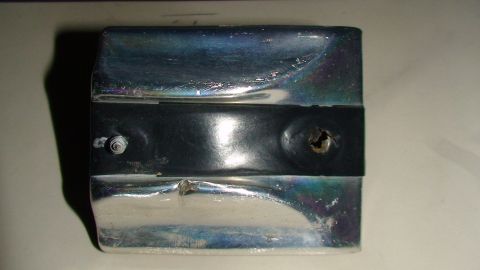 1979 Ford F-250 - A close-up view of a damaged chrome and black trim piece, likely from a vehicle's exterior.