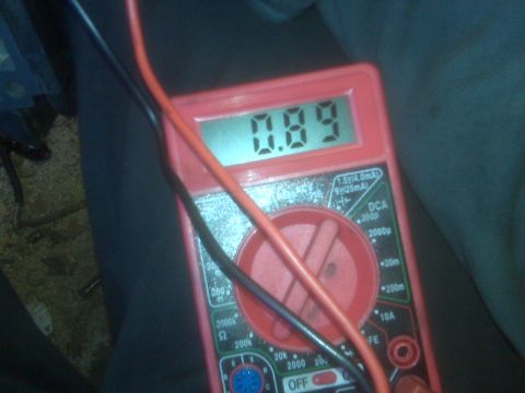 1995 Ford Bronco - A red digital multimeter displays a reading of 0.89. Red and black wires are connected to the multimeter, which appears to be measuring vol…