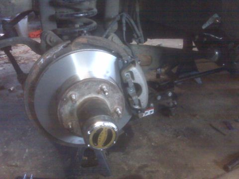 1995 Ford Bronco - A close-up view of a vehicle's front brake rotor and hub assembly, which appears to be from a 1995 Ford Bronco. The hub has a "WARN" logo v…