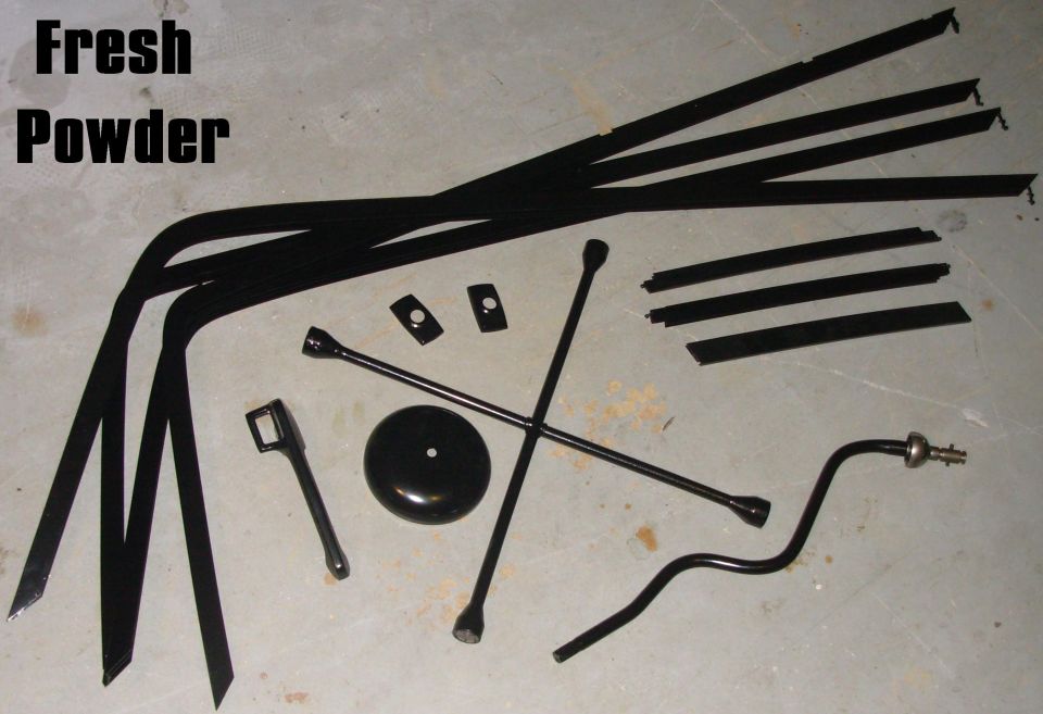 Black convertible top frame bows and hardware laid out on concrete