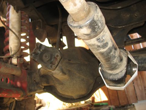 1987 Ford Bronco - A close-up view of the underside of a vehicle, showing the differential housing and a driveshaft with a Spicer yoke. The suspension compone…