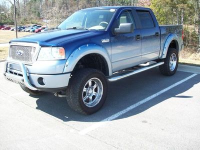 1993 Ford Crown Victoria - A modified blue and silver Ford F-150 pickup truck is parked in a lot. The truck features aftermarket chrome wheels, fender flares, and a b…