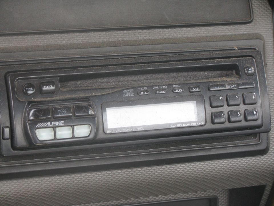Alpine car stereo with CD player and digital display in vehicle dashboard.