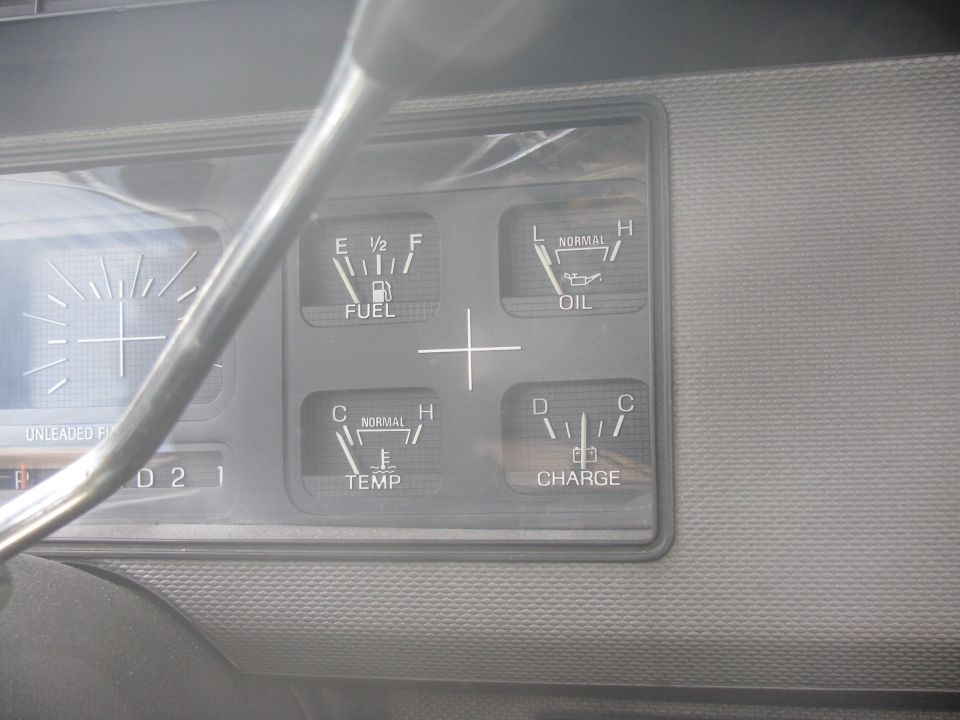 Vehicle dashboard gauges: fuel, oil, temperature, and charge indicators.