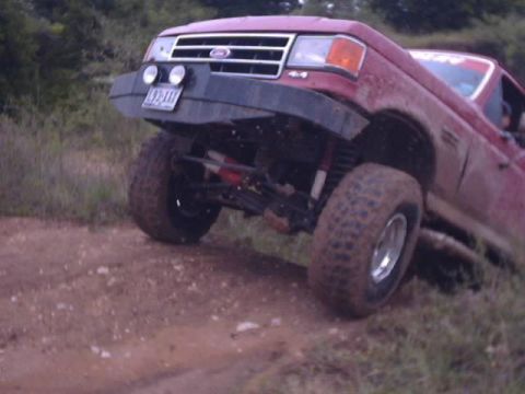1989 Ford Bronco - This red Ford Bronco, likely from the late 1980s, is equipped with a heavy-duty aftermarket bumper and large off-road tires, suggesting it'…