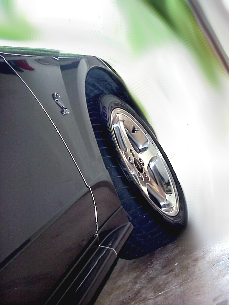 Black 2001 Ford Mustang fender with chrome wheel and pony emblem