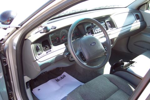 2001 Ford Crown Victoria - The interior of a Ford Crown Victoria shows the dashboard, steering wheel, and passenger seat. A piece of paper with the Mobil logo is on t…