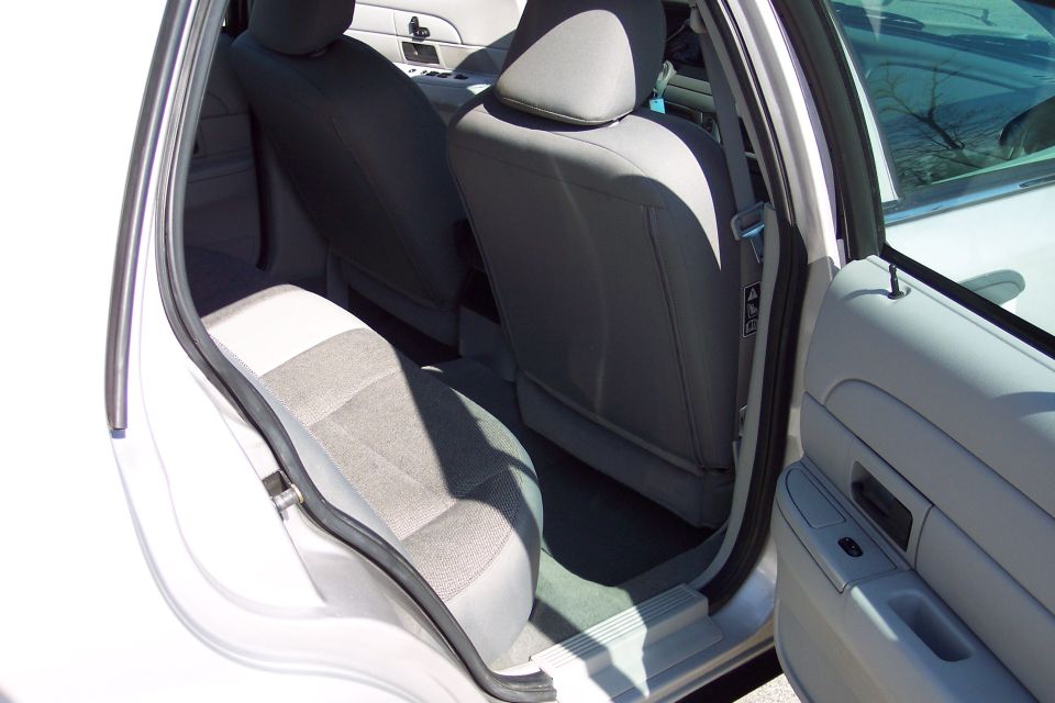 Interior of a white 2001 Ford Crown Victoria, rear passenger seats and door panel.