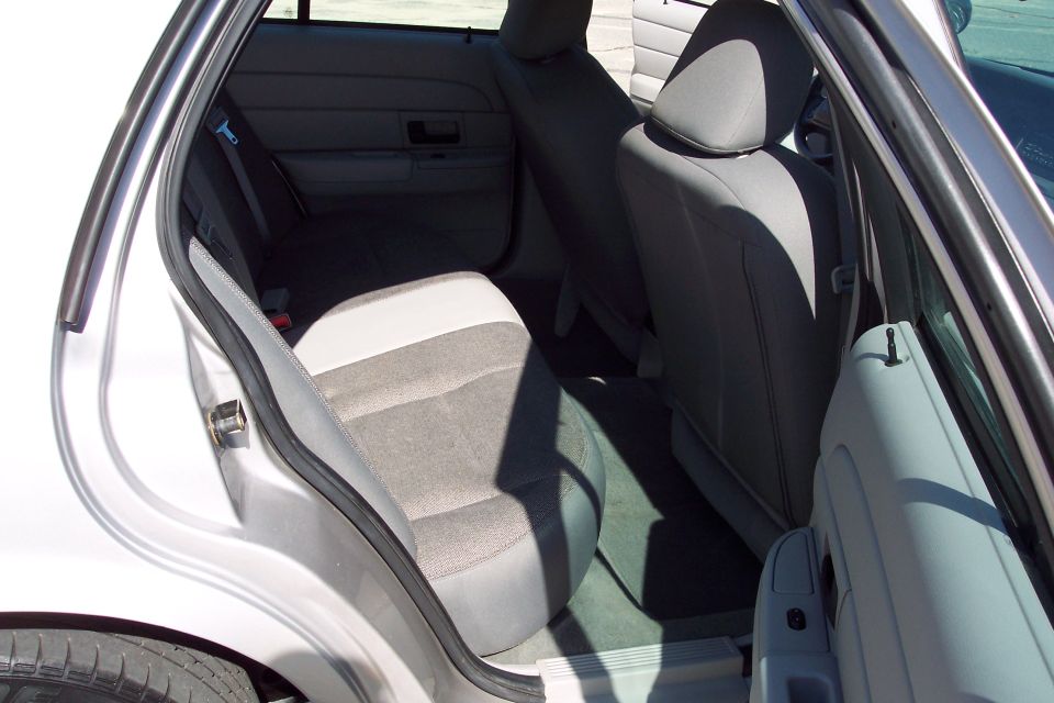 Interior rear passenger side of a silver sedan with gray fabric seats.