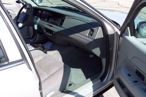 2001 Ford Crown Victoria - The interior of a 2001 Ford Crown Victoria is shown from the driver's side door, looking towards the dashboard and passenger seat. The car…