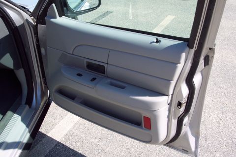 2001 Ford Crown Victoria - The interior driver's side door panel of a gray Ford Crown Victoria is shown with the door open. Visible components include the window cont…