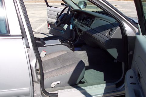 2001 Ford Crown Victoria - The interior of a silver 2001 Ford Crown Victoria is shown from the driver's side with the door open. Visible are the driver's seat, dashbo…