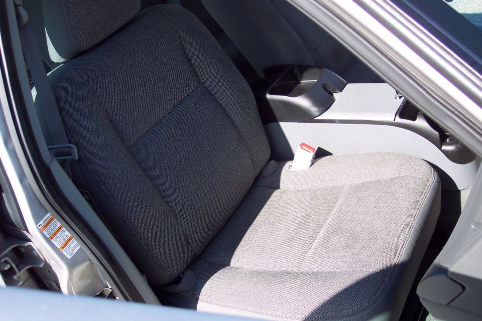 Interior view of a car's front passenger seat and center console with seatbelt.