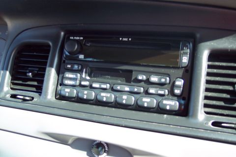 2001 Ford Crown Victoria - The interior of a 2001 Ford Crown Victoria shows the car's radio and CD player console, along with an air vent on the left. The radio has s…
