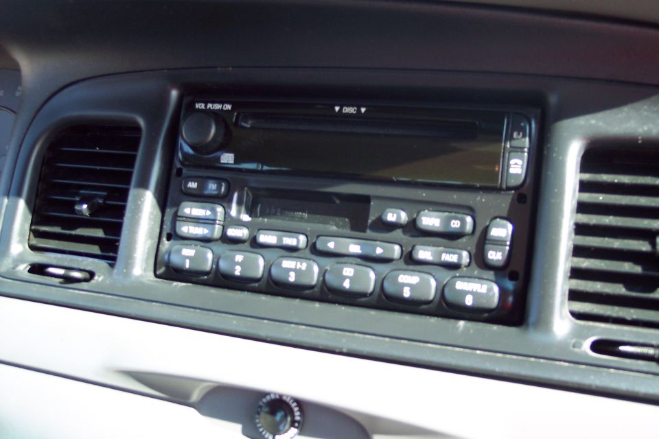 Interior view of a 2001 Ford Crown Victoria's car radio and CD player console.