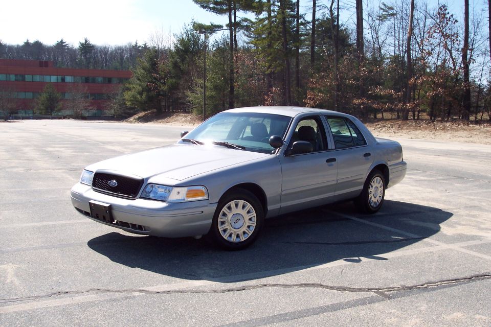 Silver 2001 Ford Crown Victoria sedan parked in an asphalt lot.