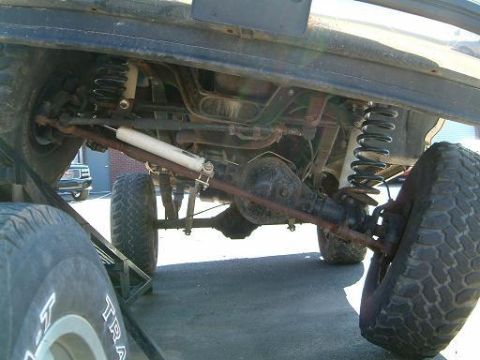 1993 Ford Bronco - The underside of a vehicle is shown, highlighting its suspension components and a solid axle setup.