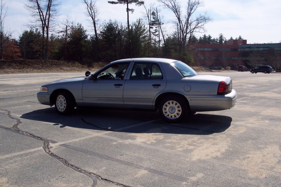 Silver 2001 Ford Crown Victoria parked in an asphalt lot.