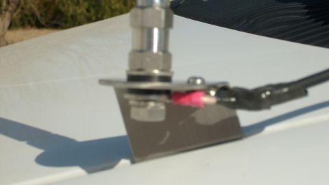 2006 Ford E250 - Metal antenna mount with wiring and connectors attached to a white surface.