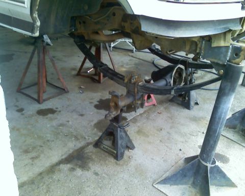 1996 Ford Bronco - Vehicle frame and suspension parts are visible while supported by jack stands.