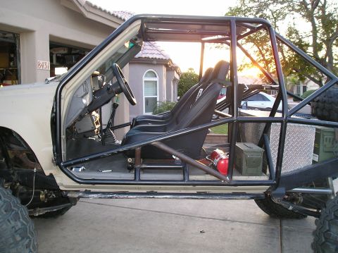 1986 Toyota Hilux - This heavily modified vehicle features a full roll cage, racing seats, and external storage boxes, suggesting it's built for off-road adven…