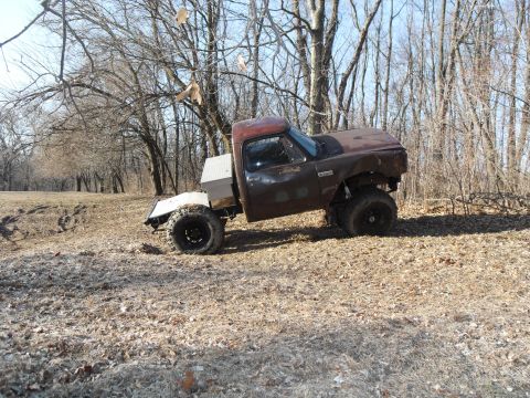 1980 Dodge Magnum - This modified pickup truck, likely from the 1980s, is shown off-road with its suspension and tires clearly visible.