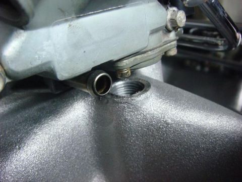 1975 Chevrolet Corvette - Detail of a carburetor fuel line fitting, showing the threaded connection point.